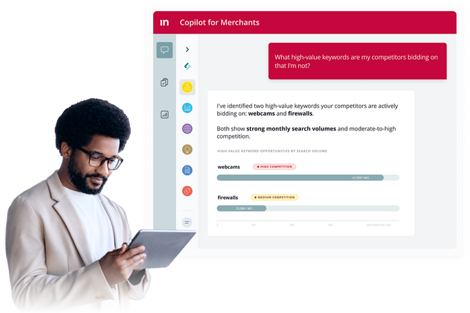 Image showing the Intershop Competitive Intelligence Agent in Copilot for Merchants with a business professional holding a tablet while the interface highlights high‑value competitor keywords such as webcams and firewalls with monthly search volume and co